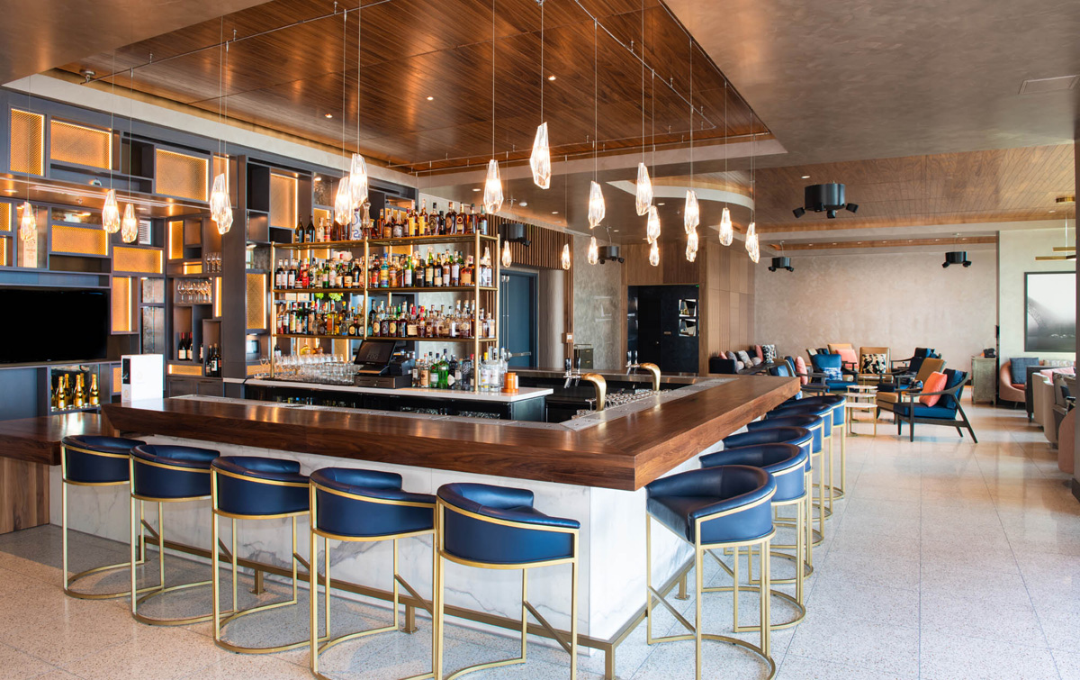 A bar with a wooden counter and blue stools
